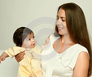 Portrait of mother and baby on white, yellow toned