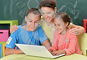 Portrait of mother and children with laptop