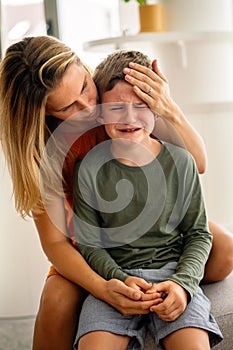 Portrait of mother consoling her crying sad injured son. Child family support parent concept