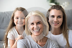 Portrait of mother, daughter and grandmother making family pictu