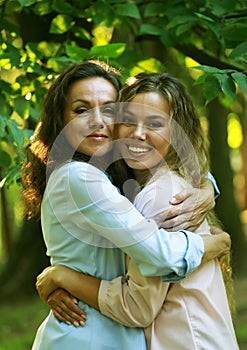 portrait of mother and daughter hugging, summer time, park