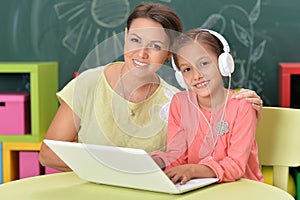 Portrait of mother and daughter using laptop