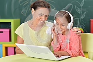 Portrait of mother and daughter using laptop