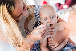 Portrait of mother feeding her baby with spoon