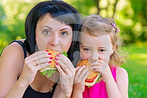 Portrait of mother with her daughter with burgers