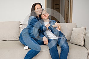 Portrait of mother and her son on sofa at home