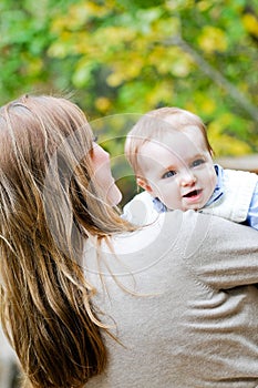 Portrait of mother holding infant son outdoors