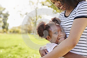 Portrait Of Mother Hugging Daughter In Park