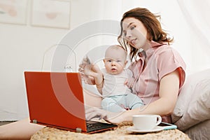 Portrait of mother and little son doing online shopping with credit card, using laptop