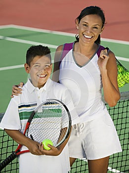 Portrait Of Mother And Son By Net On Tennis Court