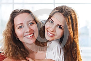 Portrait of a mother and teen daughter being close and hugging