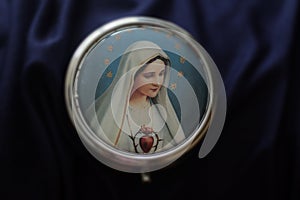 Portrait of Mother Virgin Mary on a cover of round metal rosary box. Pray rosary devotion concept. Catholic religion symbol.