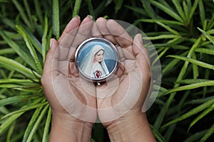 Portrait of Mother Virgin Mary in open hands. Love devotion and believe in God concept.