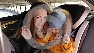 Portrait of a mother with a young son in the car, they playing hide and seek.