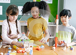 Portrait Of Multi-Cultural Children  playing with colorful blocks on table in a primary interracial classroom. Education brain