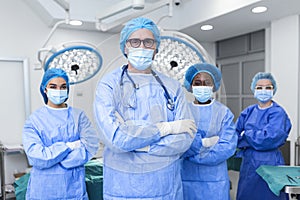 Portrait Of Multi-Cultural Medical Team Standing In operating theatre. Portrait of successful medical workers in surgical uniform