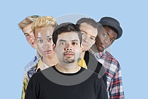 Portrait of multi-ethnic friends standing in line over blue background