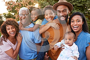 Portrait Of Multi-Generation African American Family Relaxing In Garden At Home Together