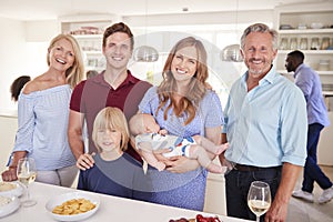 Portrait Of Multi-Generation Family And Friends Gathering In Kitchen For Celebration Party