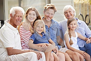 Portrait Of Multi Generation Family Relaxing On Deck At Home