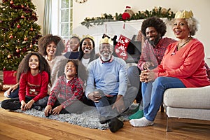 Portrait Of Multi Generation Family Sitting In Lounge At Home On Christmas Day