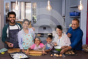 Portrait of multi-generation family smiling together while preparing food