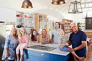 Portrait Of Multi Generation Family Standing Around Kitchen Island Together