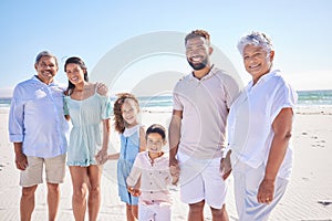 Portrait of multi generation family standing together at the beach together. Mixed race family with two children, two