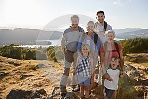 Portrait Of Multi Generation Family Standing At Top Of Hill On Hike Through Countryside In Lake District UK