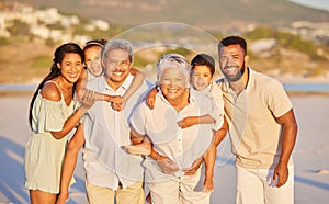 Portrait of a multi generation family on vacation standing together at the beach on a sunny day. Mixed race family with