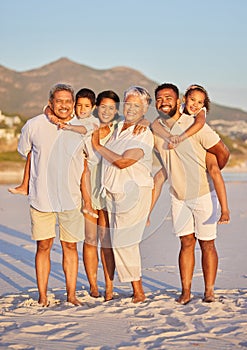 Portrait of a multi generation family on vacation standing together at the beach on a sunny day. Mixed race family with