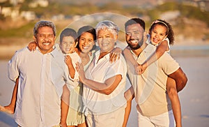 Portrait of a multi generation family on vacation standing together at the beach on a sunny day. Mixed race family with