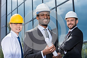 Portrait of multiethic group of professional architects in hard hats photo