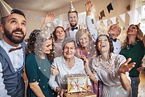 A portrait of multigeneration family with presents on a indoor birthday party.