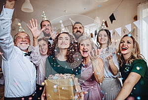 A portrait of multigeneration family with presents on a indoor birthday party.