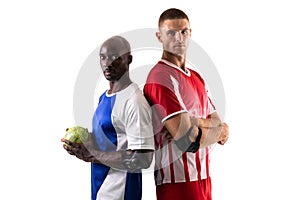 Portrait of multiracial male rival handball players standing back to back against white background