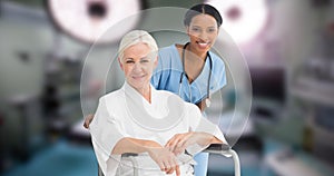 Portrait of multiracial smiling young doctor with senior woman sitting on wheelchair in hospital