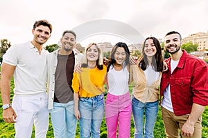 Portrait of multiracial young friends hugging each other at city park