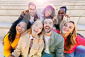 Portrait of multiracial young group of happy people laughing at camera together