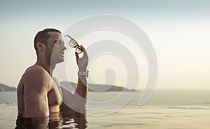 Portrait of a muscualar man relaxing in a tropical, hot water