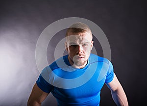 Portrait of a muscular aggressive young man standing in studio on black studio background. view with copy space.