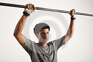 Portrait of a muscular black athlete grabbing carbon pullup bar