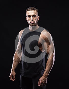 Portrait of a muscular male model against black background