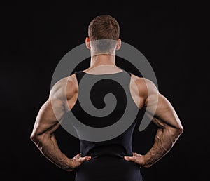 Portrait of a muscular male model against black background