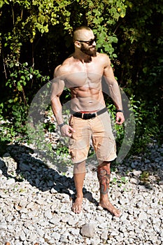 Portrait of Muscular Man Standing Outdoors in Nature