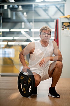 portrait Muscular young man training at gym, confident bodybuilder working out with weights in sport club, bodybuilding