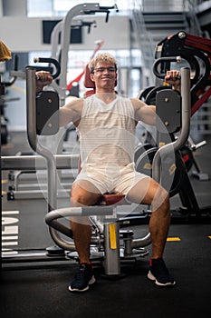 portrait Muscular young man training at gym, confident bodybuilder working out with weights in sport club, bodybuilding