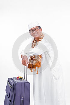 Portrait muslim old asian man with travel suitcase. going for ramadan eid mubarak celebration concept isolated over a white