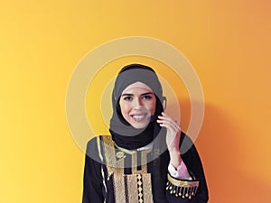 Portrait of muslim woman with headset on yellow background