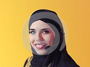 Portrait of muslim woman with headset on yellow background